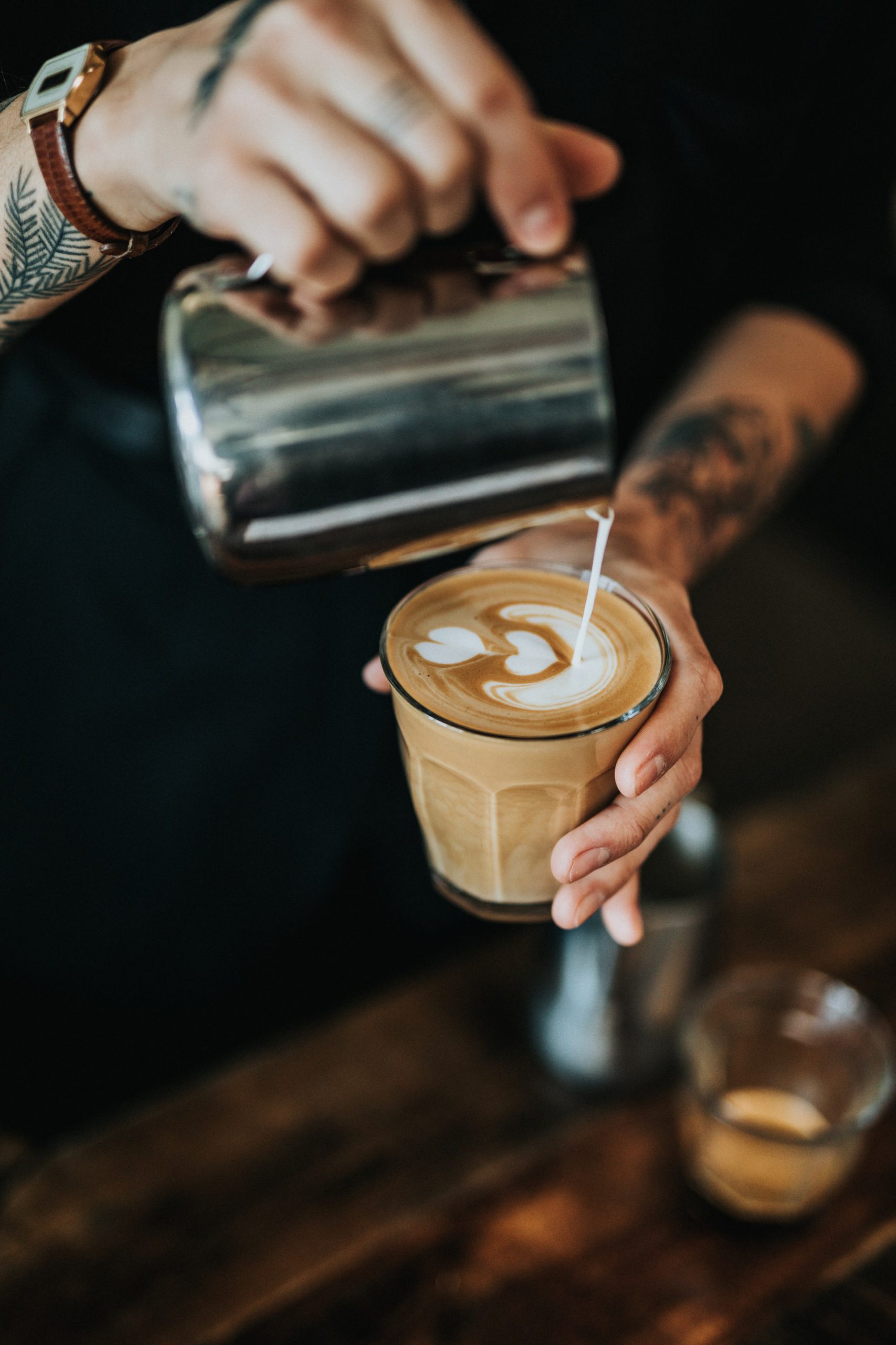 Man pouring milk into coffee